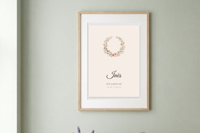 Affiche chambre bébé fille avec une couronne de fleurs à l'aquarelle et le prénom Inès, encadrée sur un mur vert sauge