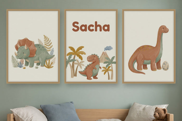 Chambre d'enfant au mur vert sauge avec trois affiches dinosaures à l'aquarelle et le prénom Sacha au-dessus d'un lit en bois